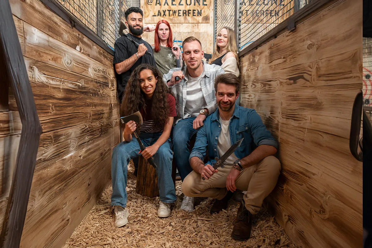 Gruppe von freunden posiert in der axezone beim Axtwerfen