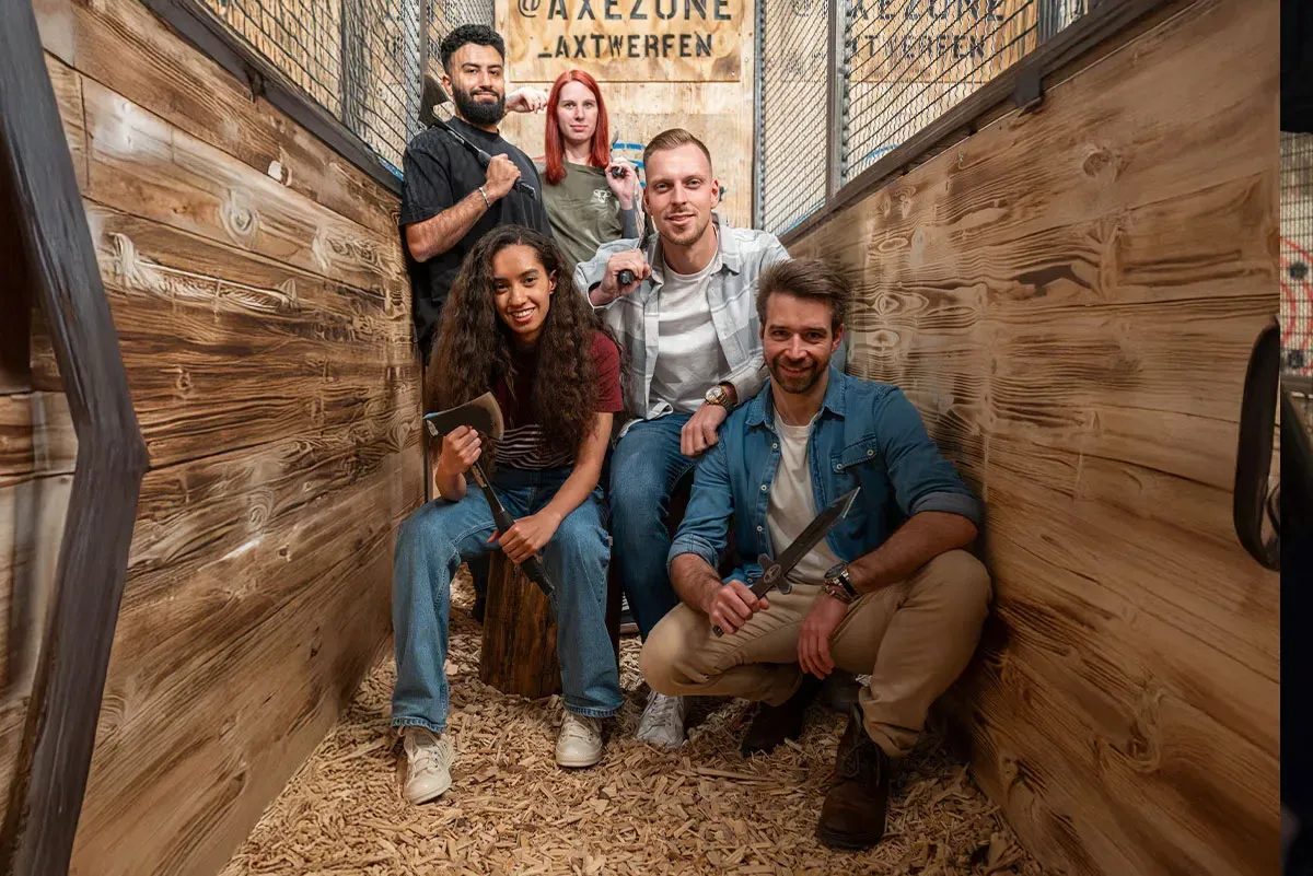 Gruppe von freunden posiert in der axezone beim Axtwerfen